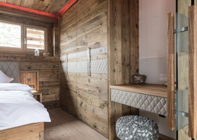 Stimmungvoll beleuchtetes Schlafzimmer aus Altholz